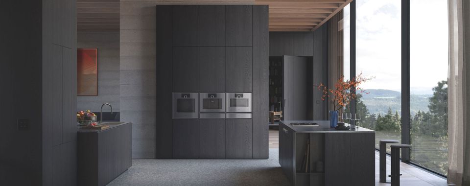 Schwarze, offen gestaltete Küche mit Einbaugeräten von Gaggenau