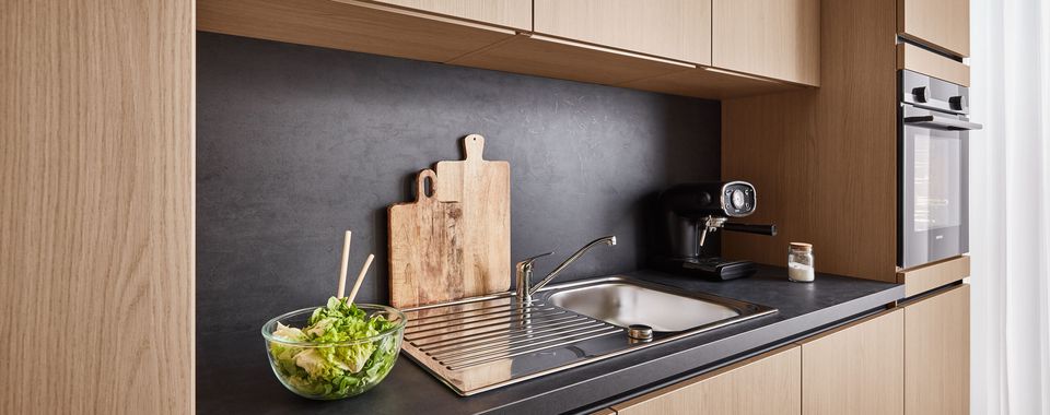 Graue Granitarbeitsplatte mit Spüle in einer Küche mit Holzfronten