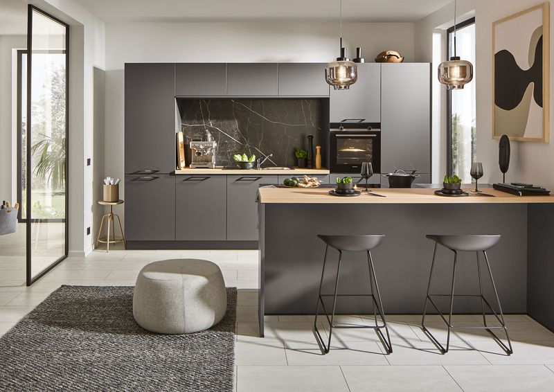 Schwarze Designküche mit Kochtresen und heller Holzarbeitsplatte
